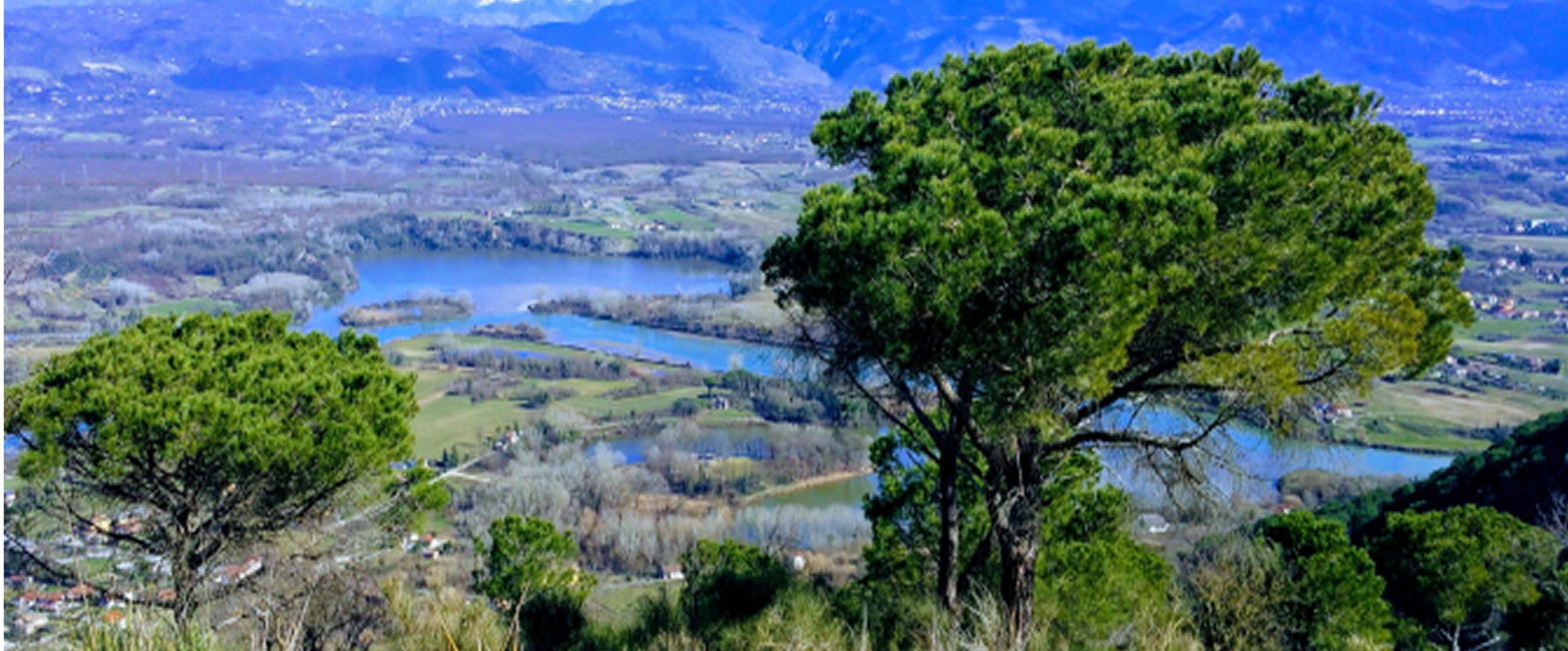 Vista di Colle Sant'angelo. si vedono degli alberi, un bacino idrico e delle montagne sullo sfondo