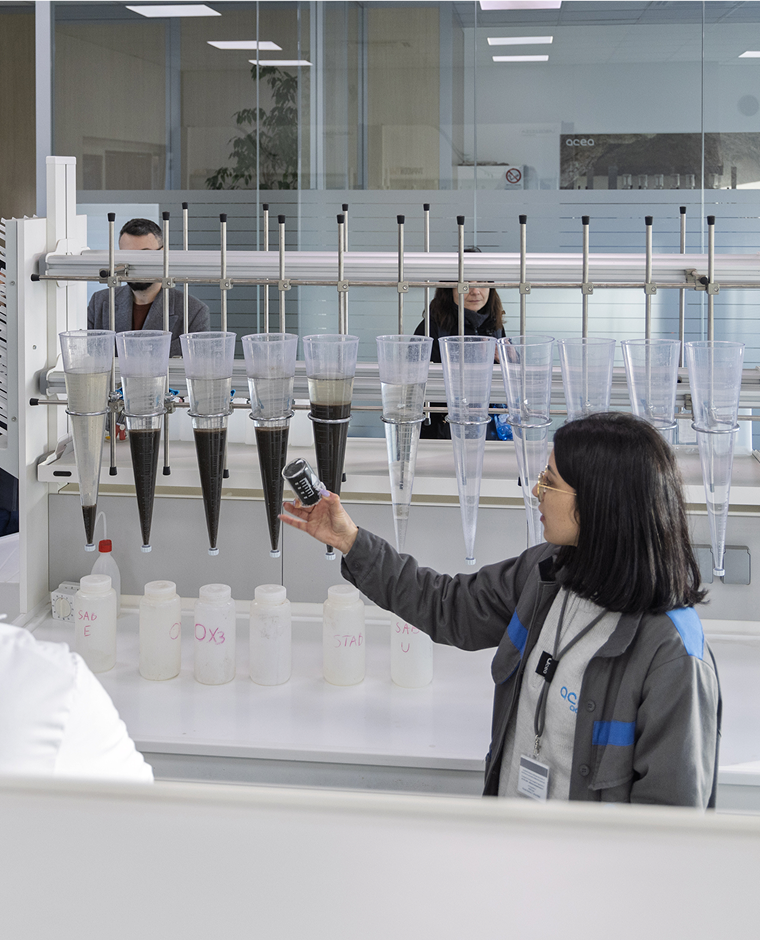 Una ragazza sfiora delle provette in un laboratorio
