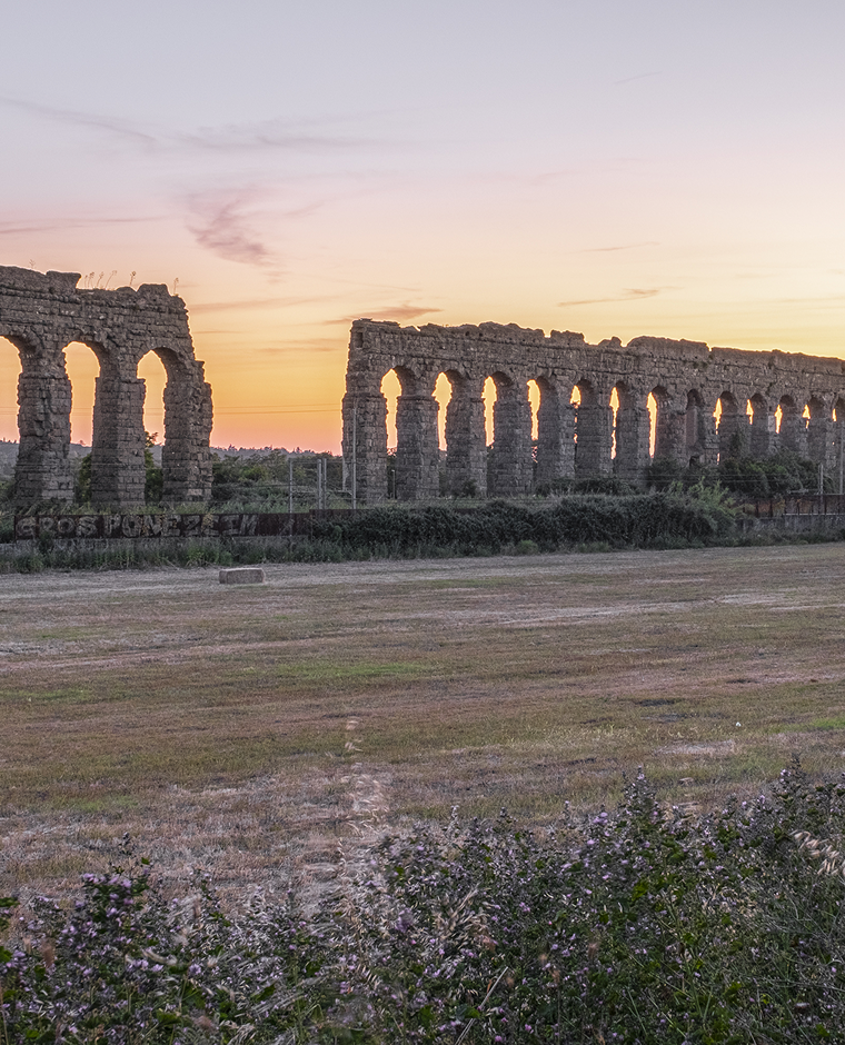 Resti dell'antico acquedotto romano presente al Parco degli Acquedotti di Roma, con il tramonto
