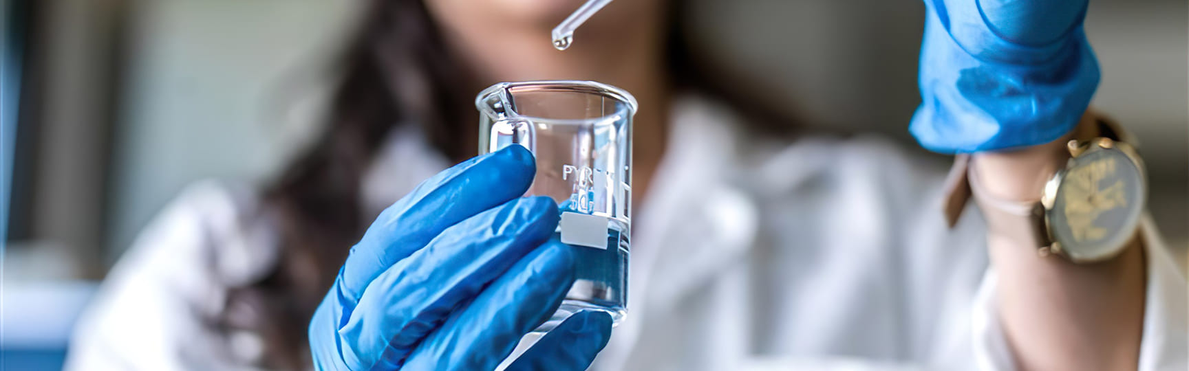 una donna in laboratorio sta versando del liquido in una provetta