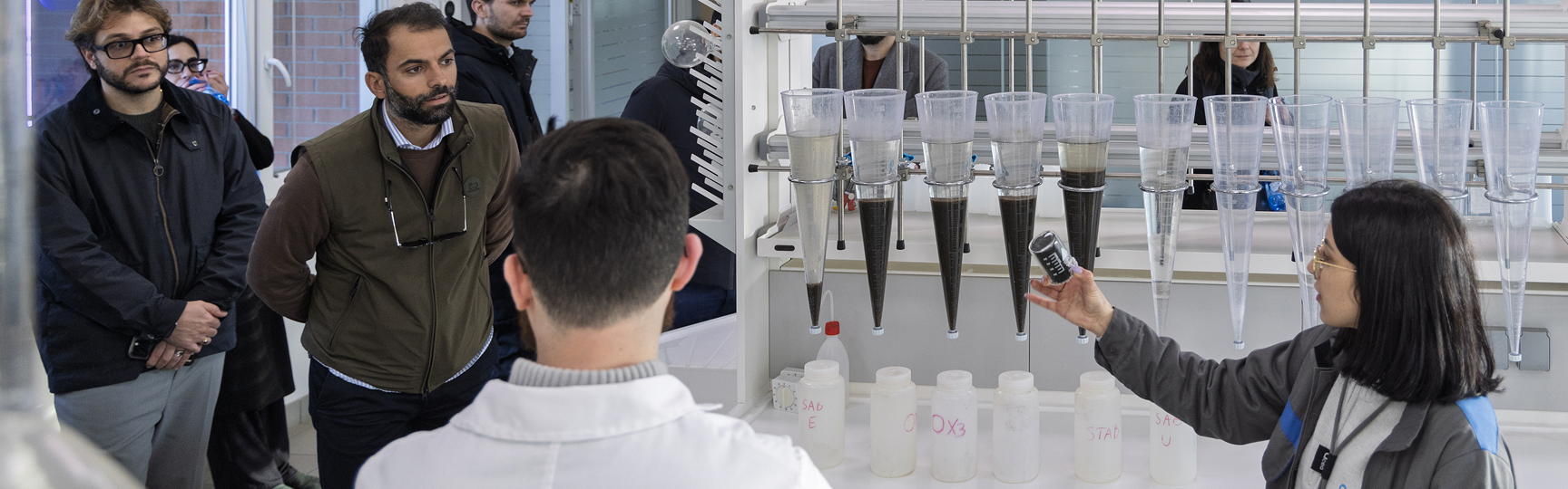 Una ragazza sfiora delle provette in un laboratorio