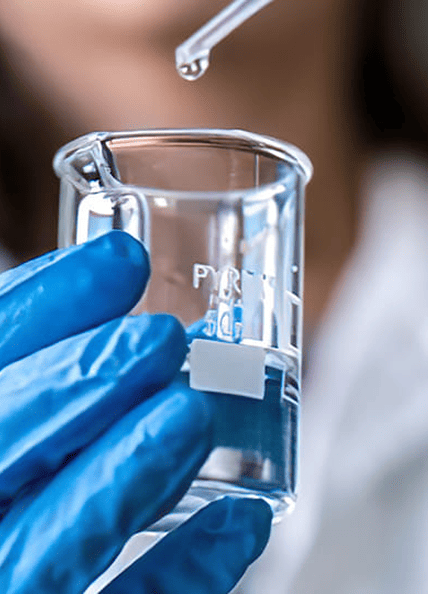 Una donna in laboratorio sta versando del liquido in una provetta
