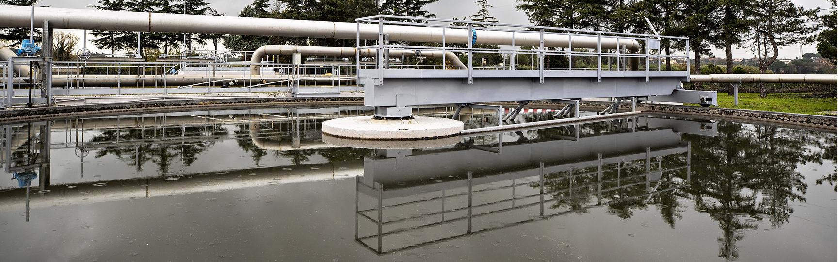 water infrastructure with a tank full of water, iron structures and trees in the background