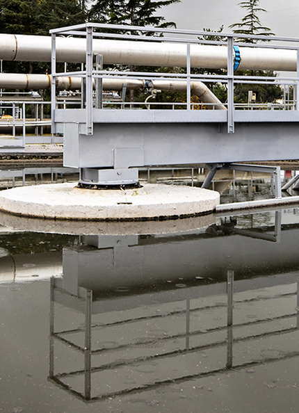 water infrastructure with a tank full of water, iron structures and trees in the background